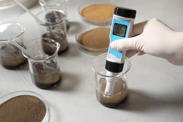 Cientista afere o ph de amostra em laboratório de análise de solo.