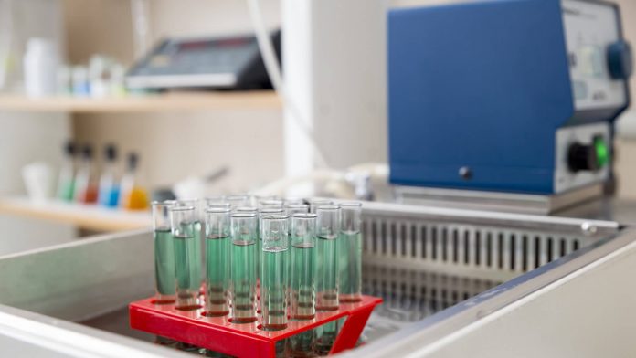 Banho ultratermostático controlando temperaturas em substâncias em tubos de ensaio no laboratório.