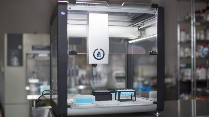Robô de pipetagem Opentrons OT-2 em bancada de laboratório.